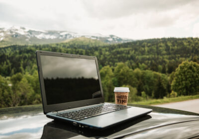 laptop-takeaway-coffee-car-s-hood-with-beautiful-natural-scenery-background